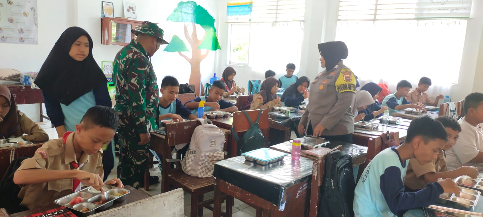 Bhabinkamtibmas Polsek IV JURAI Bersama Babinsa Painan Timur Kawal Kegiatan Pendistibusian Makan Siang Bergizi.